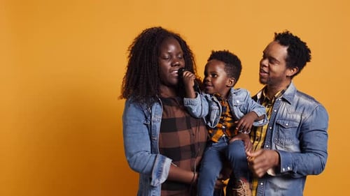 African American Mom and Dad Teaching Their Son How to Sing in Studio