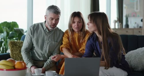 Family Looking at Laptop on Couch