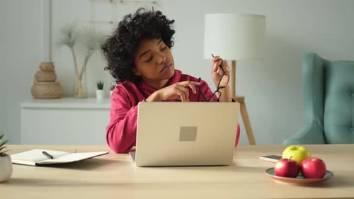 African American Girl Using Laptop at Home Office Looking at Screen Typing Chatting Reading Writing