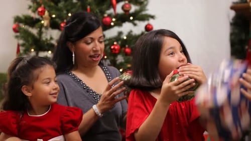 Family opening presents at Christmas celebration in home