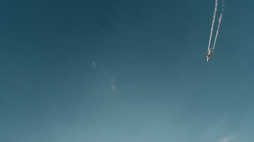 Jet Aircraft Flying with Contrails in Blue Sky