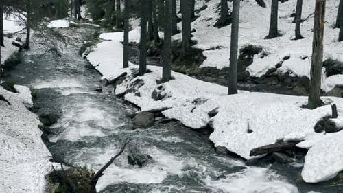 Klare Wassertextur im Dampf. Schneller Wasserfluss mit verschneiten Ufern im Wald. Stony River Rapids im W...