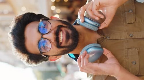 Happy Young Adult Man in Wireless Headphones Choosing Listening Music Dancing Outdoors City Street