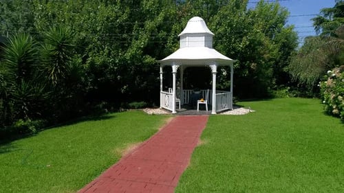 White Gazebo in a Lush Green Garden