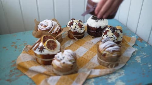 Female Hands Putting Easter Cakes Creatively Decorated with White Icing Candied Fruits Nuts and
