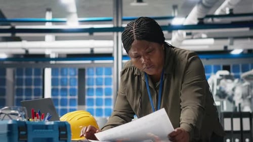 African American Technician Reading Documents in the Manufacturing Plant
