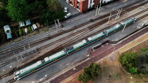 Aerial view of a passenger train on tracks near a suburban area