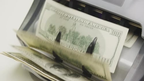 Counting Machine Processing US Dollar Bills