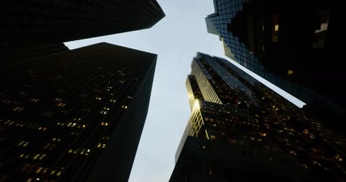 Skyward View of Towering Skyscrapers Illuminating the Dusk Cityscape