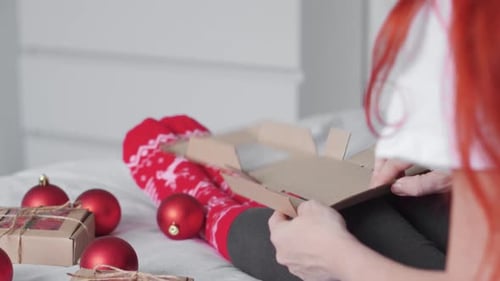 Person Assembles Christmas Box Among Ornaments