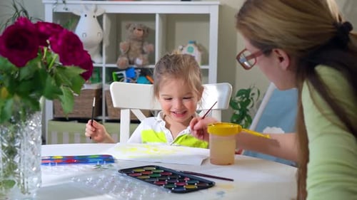 A Child and a Woman Painting Together with Watercolor Paints