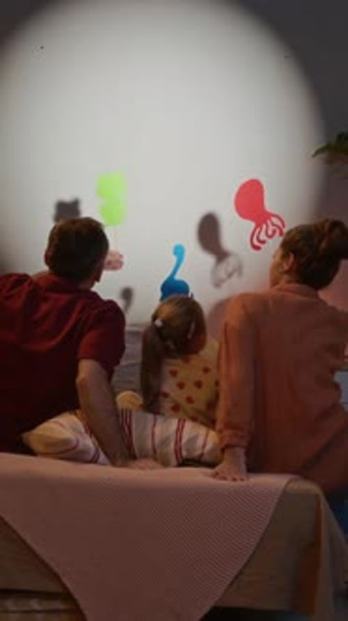 Familie spielt Schattenpuppenspiel