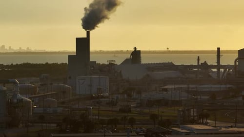 Industrial Buildings With Smoke At Sunset Near Coast
