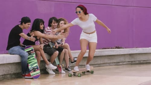 Friends sitting together and enjoying skateboarding on street
