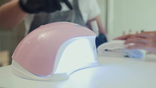 Unrecognizable Woman Putting Polished Nails in UV Lamp