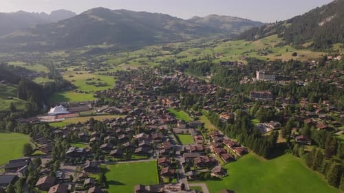 Beautiful Aerial View of Typical Alpine Town in Wide and Green Valley Panoramic Mountain Landscape