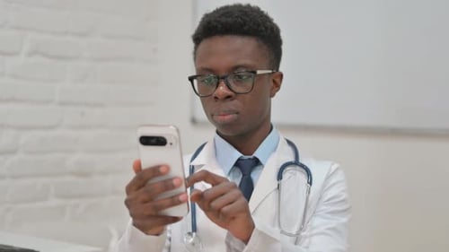 Young Doctor Using Mobile Phone in Hospital