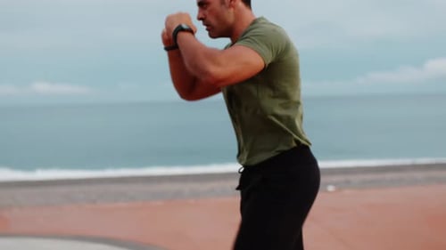 Muscular Man Boxing on Sandy Ocean Beach