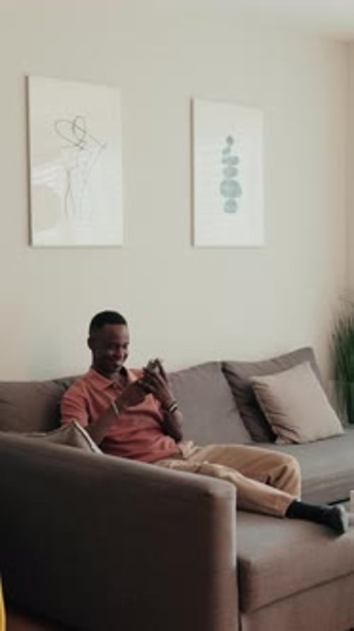 Man Relaxing at Home While Using Mobile Phone
