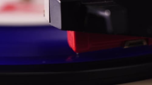 Placing Gramophone Needle on Spinning Blue Vinyl Record, Close Up. Listening Vintage Audio Recording