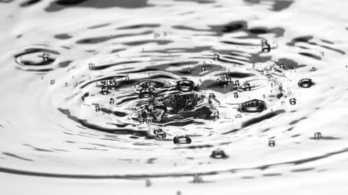 Water Drop Creating Ripples and Bubbles