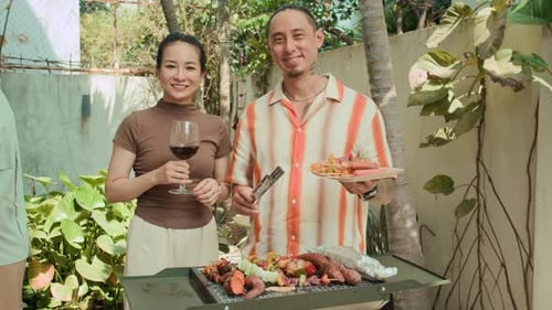 Adults Grilling Food in a Tropical Garden Setting