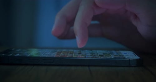 Hand Swiping Phone Touchscreen at Night