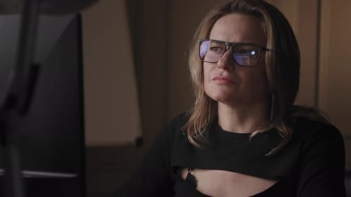 A Woman is Working on Her Computer in the Office Late at Night Showing Focus and Dedication