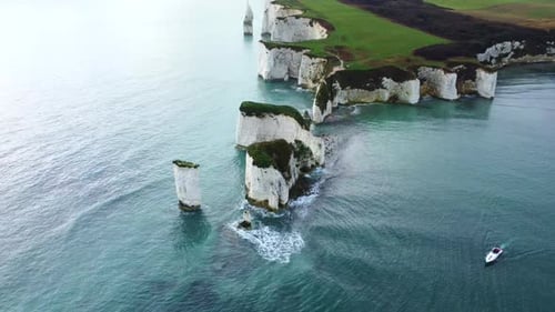 Drone shot of Old Harry Rocks with a boat in the Isle of Purbeck, England