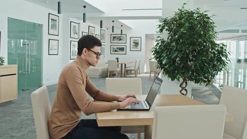 Joven empresario que trabaja en línea en una computadora portátil
