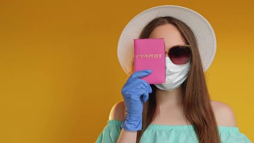 Young Woman Holding Passport Wearing Mask and Hat