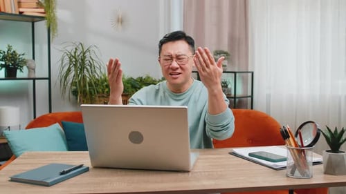 Man Frustrated with Laptop Computer at Home Office