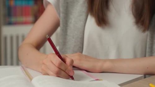 Close Up Caucasian Woman Student Writing Notes in Notebook in Library Holding Pen Preparing Exam