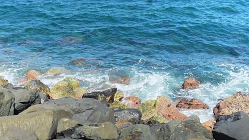 Atlantic ocean waves flowing over rocky coastline, slow motion view