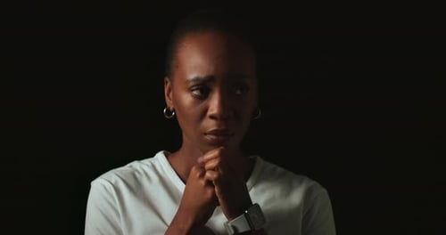 Scared, worry and black woman on dark background with fear, nervous and confused face expression
