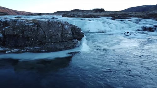 Drone fly past of a frozen river flowing into the sea