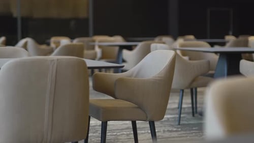 Armchairs Surround Tables Inside Spacious Hotel Cafeteria
