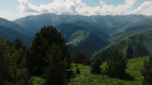 Verdant Mountain Slopes Framing a Small Remote Village Under a Cloudy Sky Showcasing Nature's