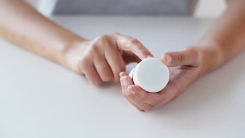 Woman Opens and Pours Pills from Pill Bottle