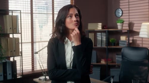 Business Woman Standing and Thinking in Office