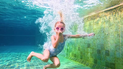 Funny child swim, dive in pool - jump deep down underwater