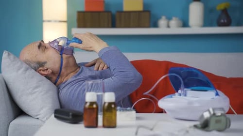 Homme alité malade sous respirateur.