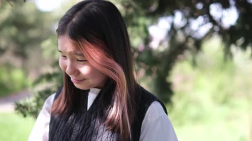 Young Woman Wiping Tears Outside in Nature
