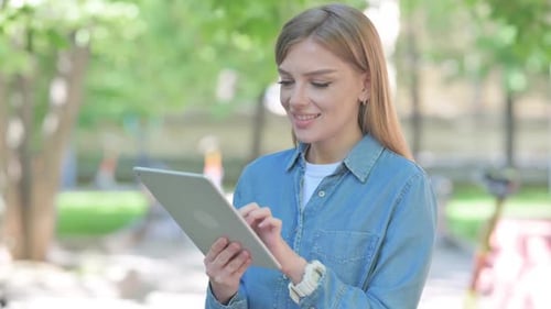 Portrait of Woman Using Digital Tablet Outdoor in Park