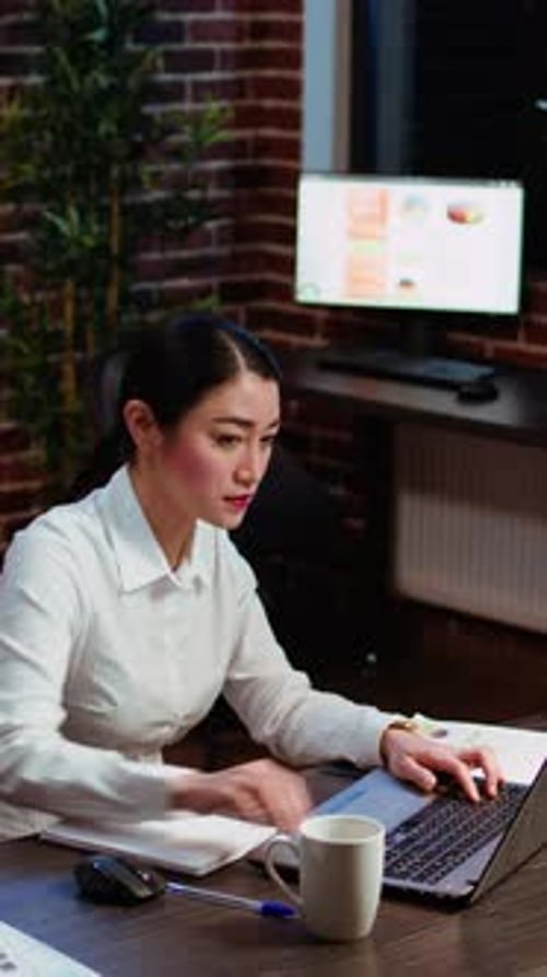 Successful Woman Working at Laptop in Office at Night