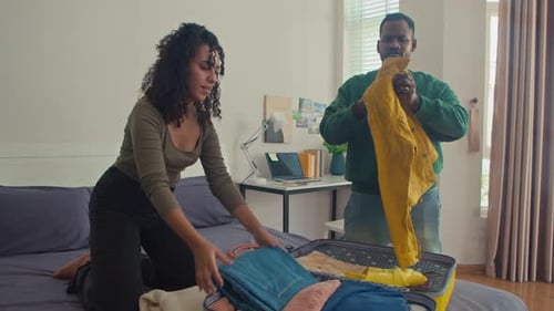 Couple Folding Clothes to Pack for Trip