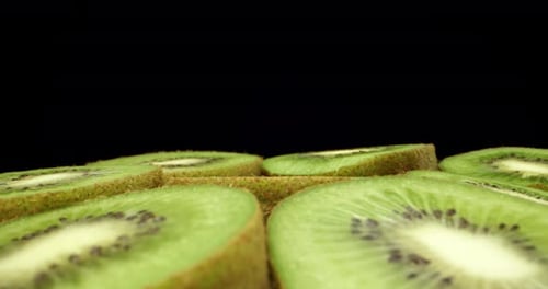 Juicy fresh kiwi fruit cut in half super close up HQ shoot fly over 4k shoot on dark background