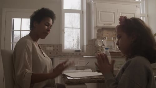 Woman and Girl Communicating at Table Indoors