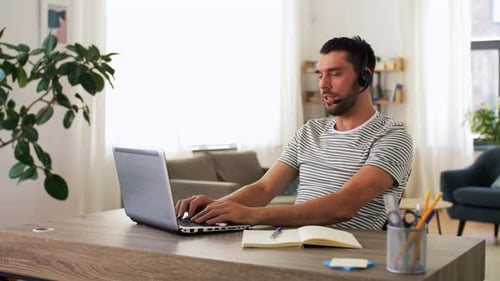 Man Working From Home on Laptop and Headset