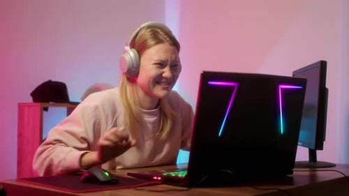 Woman Celebrates Gaming Win at Computer